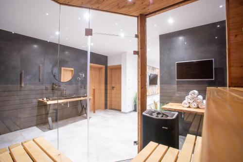 y baño con ducha acristalada y lavamanos. en Private Spa & Garden Alpi en Garmisch-Partenkirchen