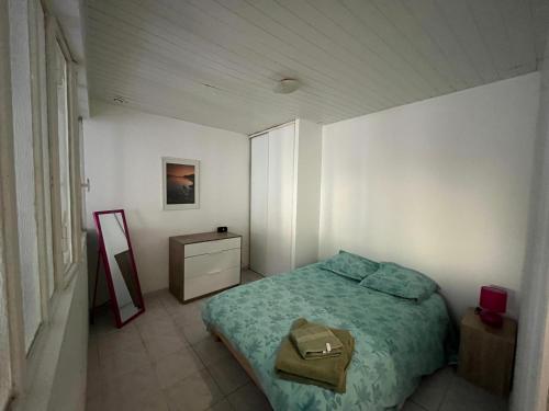 ein kleines Schlafzimmer mit einem Bett und einem Spiegel in der Unterkunft T2 rdc Muret in Muret