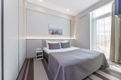 a bedroom with a large bed and a window at Grand Baltic Dunes in Palanga