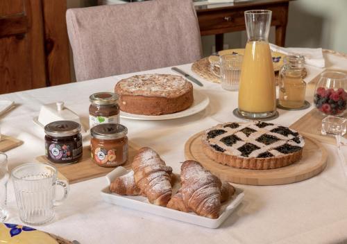 uma mesa coberta com bolos e croissants e um bolo em B&B Arianna em Ravenna