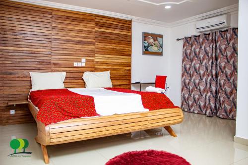 a bedroom with a large bed with a wooden wall at VILLA DE L'INTEGRATION in Ouagadougou