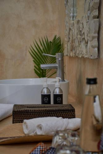 a bathroom sink with two bottles of soap and a towel at Saffron Garden Malindi in Malindi