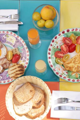a table topped with plates of bread and bowls of fruit at Hotel Terme Oriente - Beach & SPA in Ischia
