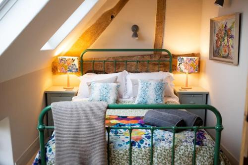 Un dormitorio con una cama con marco verde y dos lámparas. en The Byre - Beautiful Contemporary Barn - Hot Tub, en Bridgnorth