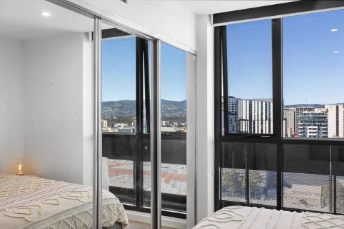 um quarto com grandes janelas com vista para a cidade em Adelaide Skyline Serenity: Gym, Pool & views em Adelaide