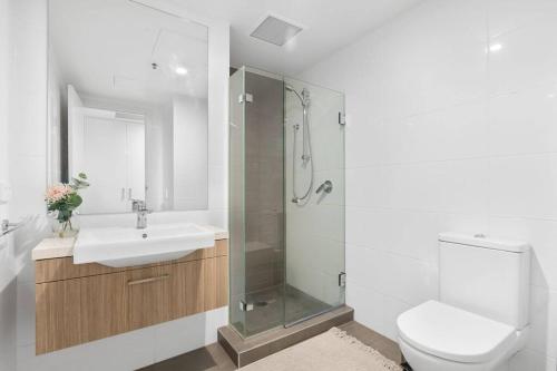 uma casa de banho com um WC, um lavatório e um chuveiro em Adelaide Skyline Serenity: Gym, Pool & views em Adelaide