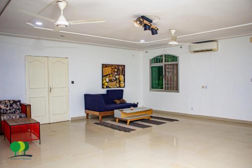 a living room with a blue couch and a table at VILLA DE L'INTEGRATION in Ouagadougou