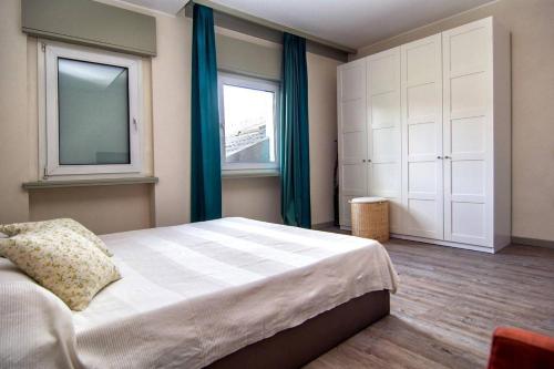 a bedroom with a bed with blue curtains and a window at Al Ponte Garnì in Pergine Valsugana
