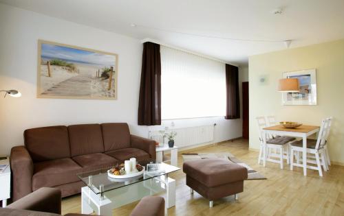 ein Wohnzimmer mit einem Sofa und einem Tisch in der Unterkunft FeWo Zornemann Whg 1 Strandhotel in Kellenhusen