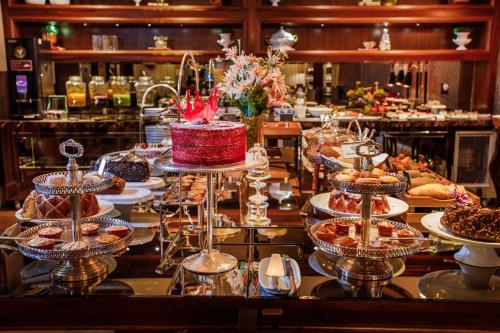 um buffet com uma mesa cheia de sobremesas e bolos em Sofistic Hotel em Itapema