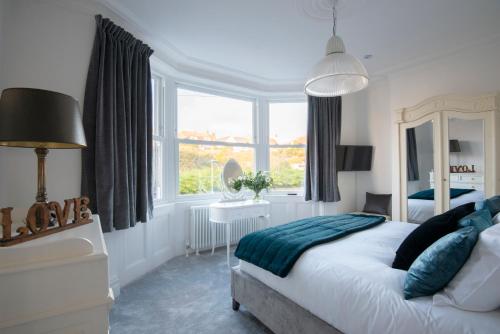 a bedroom with a bed and a large window at Cliffhanger House - Sleeps 12-14 Sea Views in Hollington