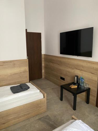 pokój z łóżkiem i stołem z telewizorem z płaskim ekranem w obiekcie Aparthotel Łódź 55 Piotrkowska w Łodzi