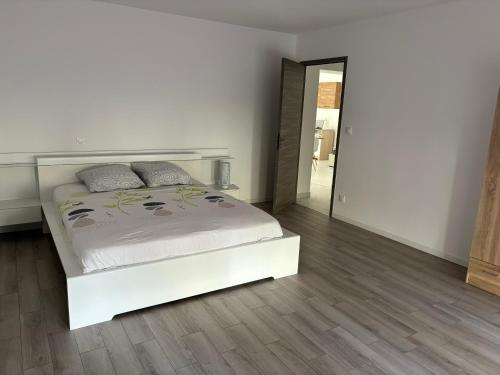 a white bedroom with a bed and a mirror at LG1 in Saint-Dizier