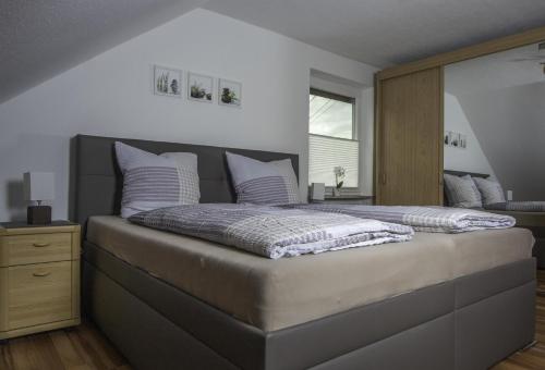 a bedroom with a large bed with white pillows at Weinstube Ferienwohnungen Johann Benzschawel in Irsch