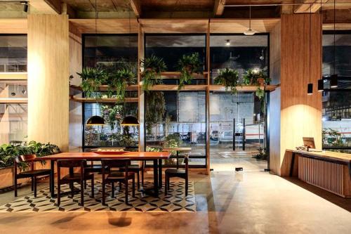 a dining room with a table and chairs and potted plants at Casa Juanito Coworking El Nogal in Zona Rosa in Bogotá