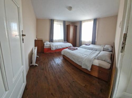 - une chambre avec 2 lits et 2 fenêtres dans l'établissement Къща за гости Casa Blanca, à Targovichté