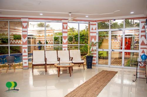 a lobby with chairs and a table and windows at VILLA DE L'INTEGRATION in Ouagadougou