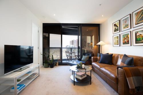 a living room with a couch and a flat screen tv at Fantastic Views at Luxury Prima Pearl Tower in Melbourne