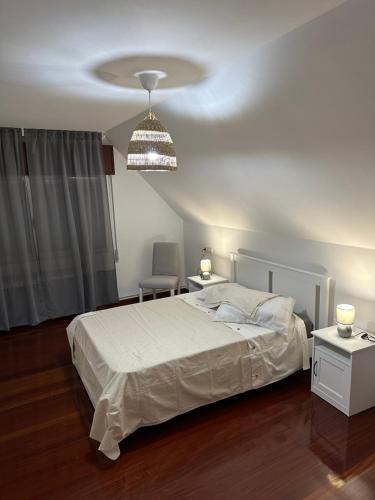 - une chambre avec un lit et un lustre dans l'établissement Casa Ponte Maria, à Pobra do Caramiñal