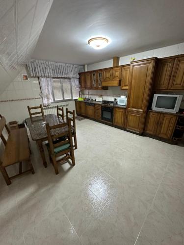 - une cuisine avec des placards en bois, une table et des chaises dans l'établissement Casa Ponte Maria, à Pobra do Caramiñal