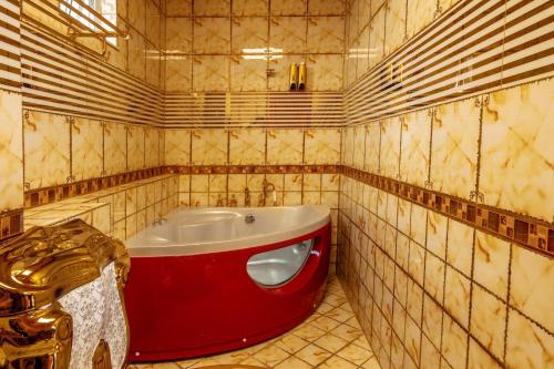 W pokoju wyłożonym kafelkami znajduje się łazienka z czerwoną wanną. w obiekcie KEN 2 HOTEL w Ho Chi Minh