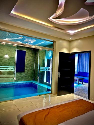 a bathroom with a swimming pool with a large window at شقق منازل الدانة للشقق المخدومة in Abha