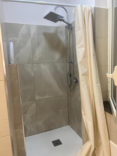 una doccia con porta in vetro in bagno di Conny Home ad Acerra