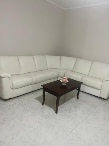 un soggiorno con divano bianco e tavolino da caffè di Conny Home ad Acerra