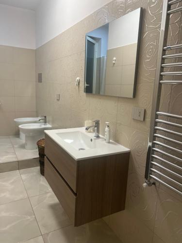 bagno con lavandino, servizi igienici e specchio di Conny Home ad Acerra