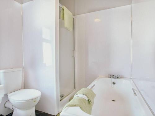 a white bathroom with a toilet and a bath tub at Halifax Town House - Cosy - Sleeps 5 in Halifax