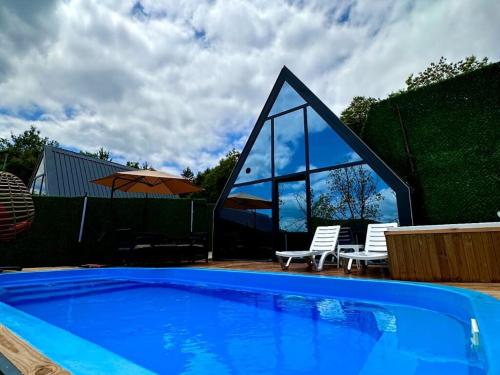 a swimming pool with two chairs and an umbrella at Mira Deluxe Bungalov in Sapanca