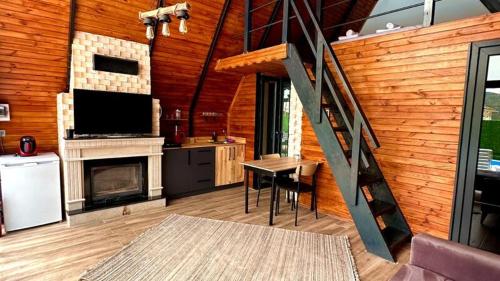 ein Wohnzimmer mit einem Kamin und einer Treppe in einem Haus in der Unterkunft Mira Deluxe Bungalov in Sapanca