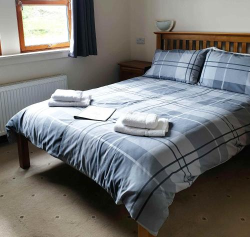 a bedroom with a bed with two towels on it at Loch Erisort Hotel in Balallan