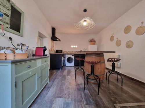 eine Küche mit einer Theke, einem Tisch und Stühlen in der Unterkunft Maison de famille in Bouillargues