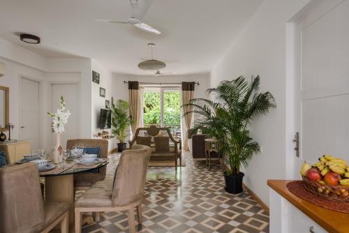 a kitchen and living room with a table and chairs at La Mer Apartments - 10 mins Drive to Candolim Beach - 20 mins from Panjim in Nerul