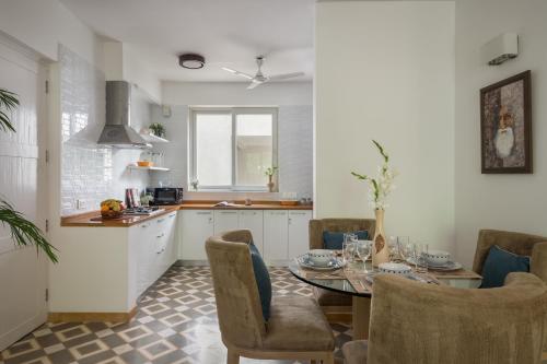 a kitchen and dining room with a table and chairs at La Mer Apartments - 10 mins Drive to Candolim Beach - 20 mins from Panjim in Nerul