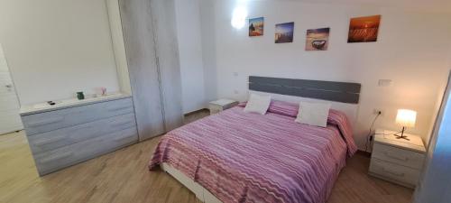 a bedroom with a bed with a purple comforter at Casa Terra Del Sole in Pula