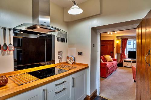 a kitchen with a counter top and a living room at Finest Retreats - Clematis Cottage in Stogursey