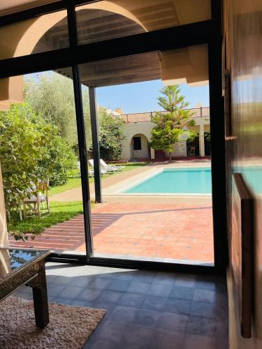 a view of a swimming pool through a glass door at Villa MsHolidays Victoria privatisée Marrakech in Marrakech