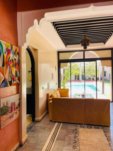 a living room with a couch and a pool at Villa MsHolidays Victoria privatisée Marrakech in Marrakech
