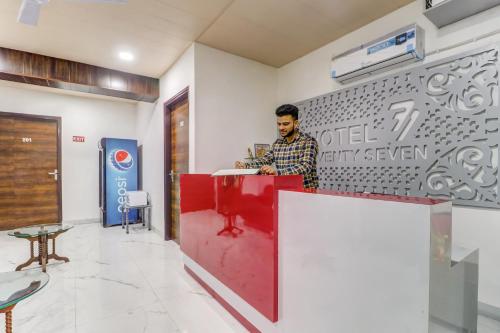 a man standing at a counter in a room at Super Townhouse 687 Hotel 77 in Ludhiana