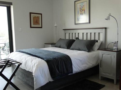 a bedroom with a large bed and a table at 14 at Karee in Stilbaai