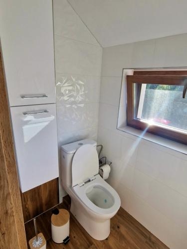 niewielka łazienka z toaletą i oknem w obiekcie Noclegi Bumerang w miejscowości Święta Katarzyna
