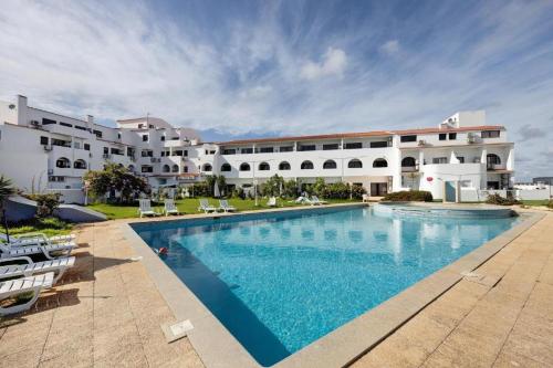a large swimming pool in front of a building at Elm Apartament in Sagres