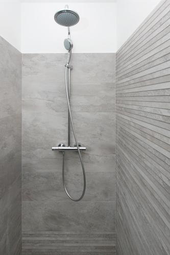 a shower with a shower head in a bathroom at Villa Hera Sevid in Sevid