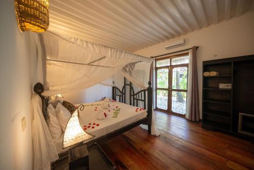 1 dormitorio con 1 cama con dosel en Beachfront Turtle House ZanzibarHouses, en Kiwengwa