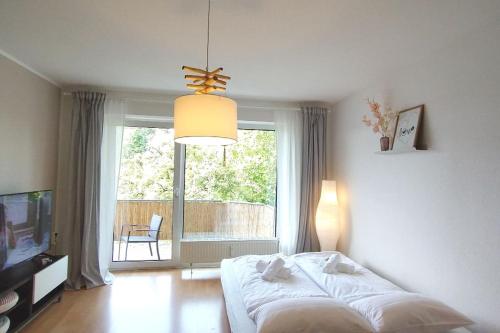 1 dormitorio con cama y ventana grande en Cozy home - Willkommen in Aachen - Boxspringbett - Balkon 
