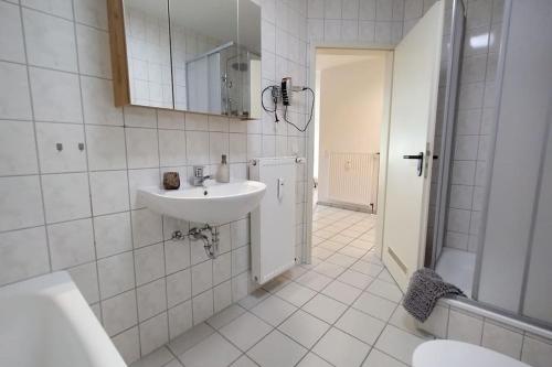 Baño blanco con lavabo y espejo en Cozy home - Willkommen in Aachen - Boxspringbett - Balkon 