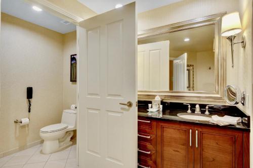 a bathroom with a toilet and a sink and a mirror at Strip View Balcony Suites - No Resort Fee ! in Las Vegas