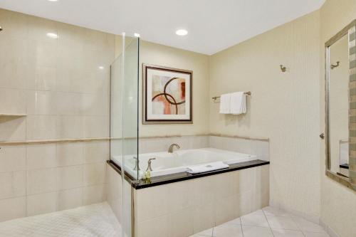 a bathroom with a bath tub and a shower at Strip View Balcony Suites - No Resort Fee ! in Las Vegas